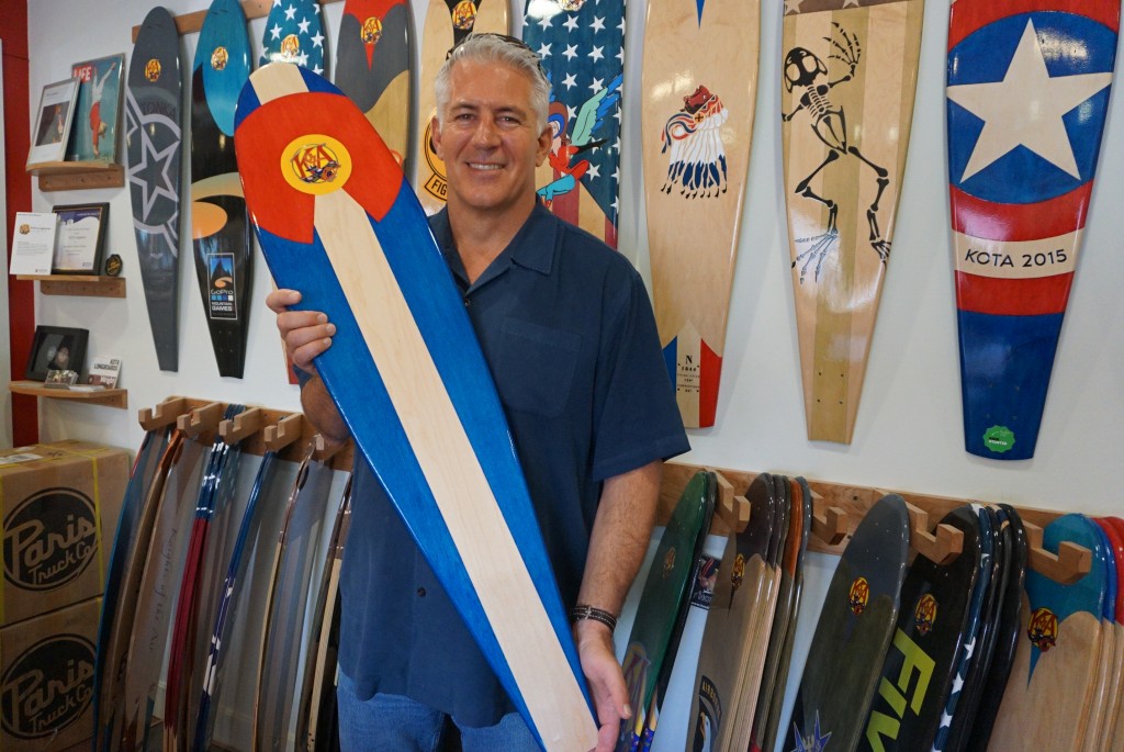 Mike Maloney shows off one of his company's longboards. (George Demopoulos)