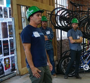 Owner Bryce Miller speaks to attendees at the shop on the corner of Ninth and Broadway. (Burl Rolett)