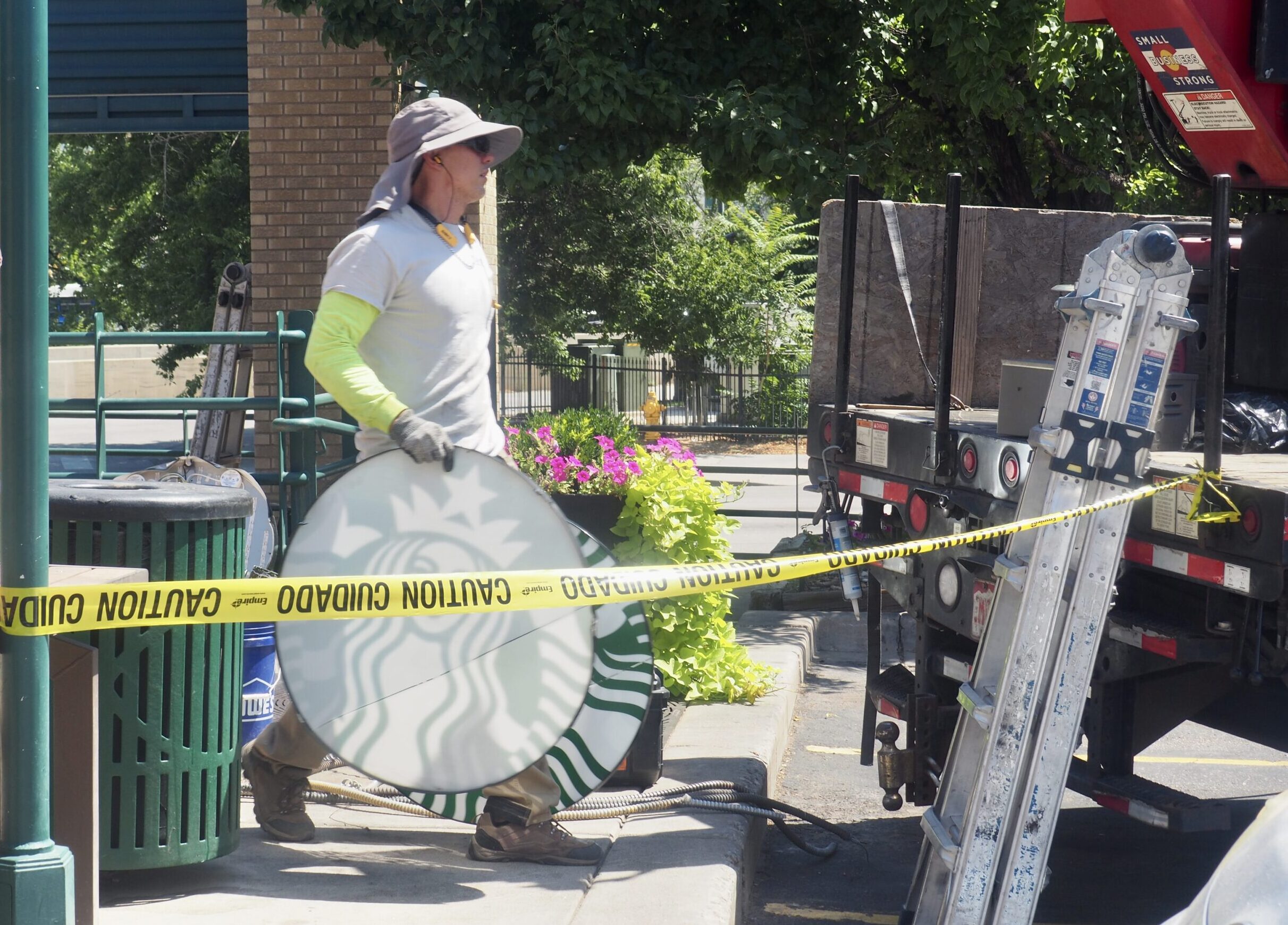 Construction worker removing Starbucks signage