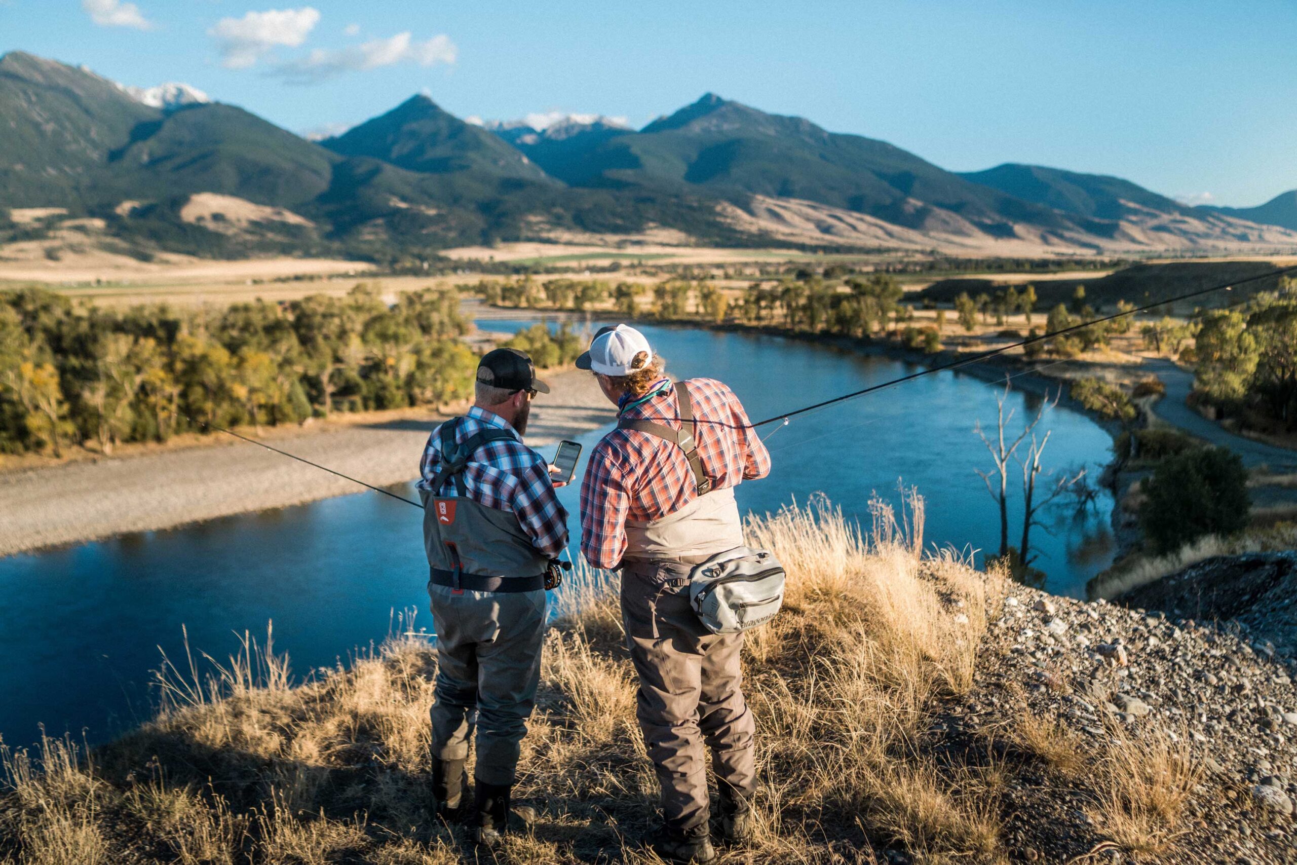 Fishing and paddle app nets $2M in funding 1 65c25bed39929d111118c450 two men consulting onwater app on landscape above river scaled