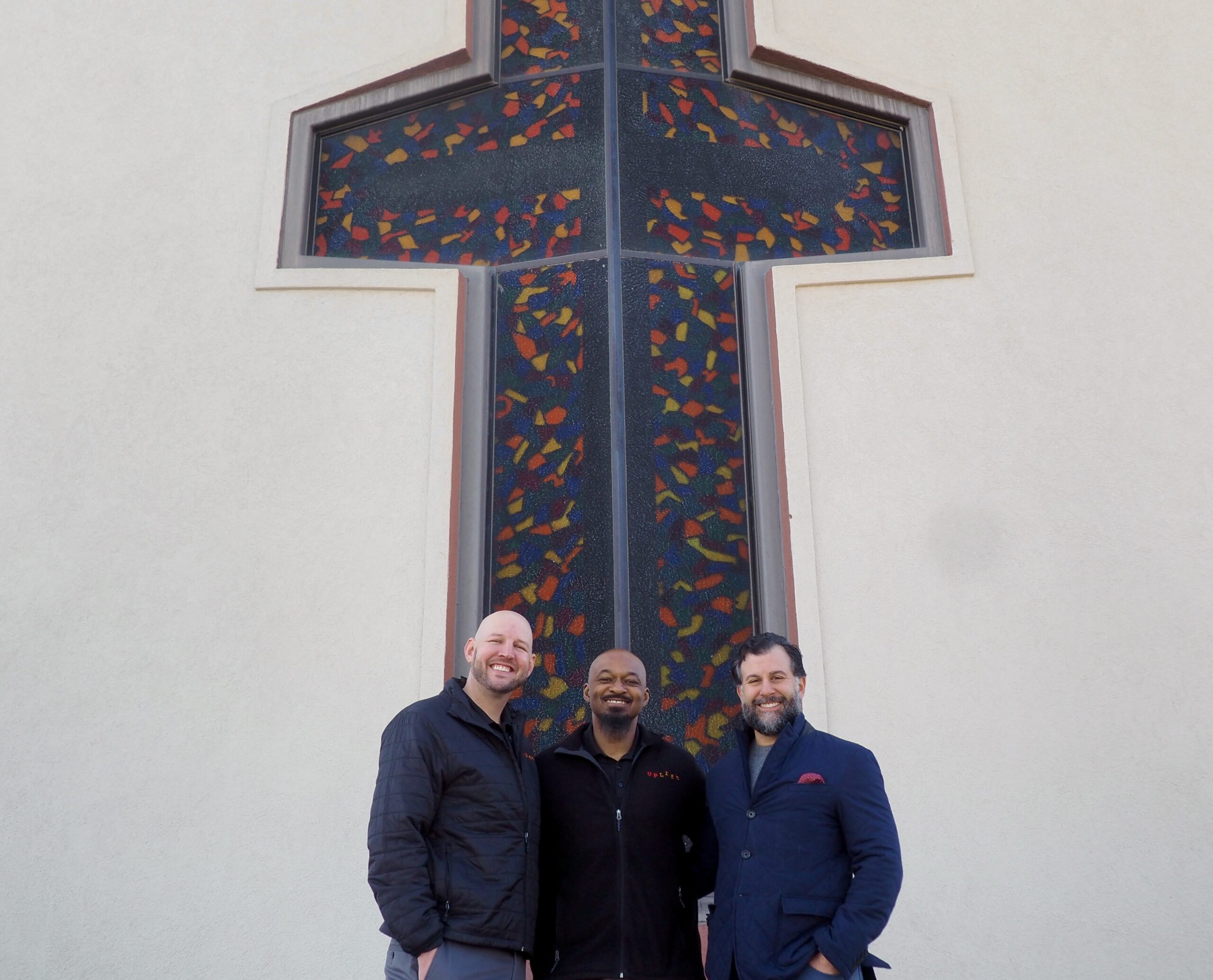 Brian Stamer, left, stands with Joe Sanders and Anthony Albanese outside the nonprofit's new home. (Matt Geiger/BusinessDen)
